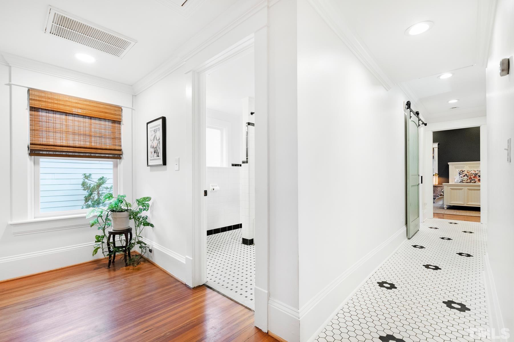308 Perry Street Raleigh, NC 27608 - Photo 20 of 30 a view of a hallway with wooden floor and a bathroom