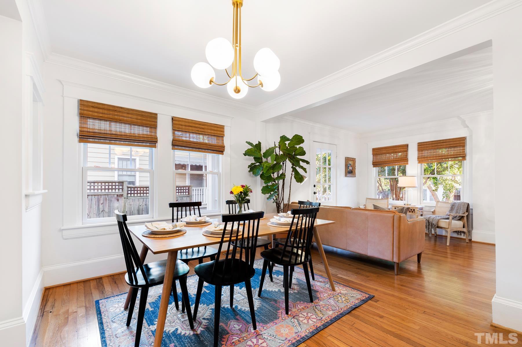 308 Perry Street Raleigh, NC 27608 - Photo 6 of 30 a view of a dining room with furniture wooden floor and chandelier