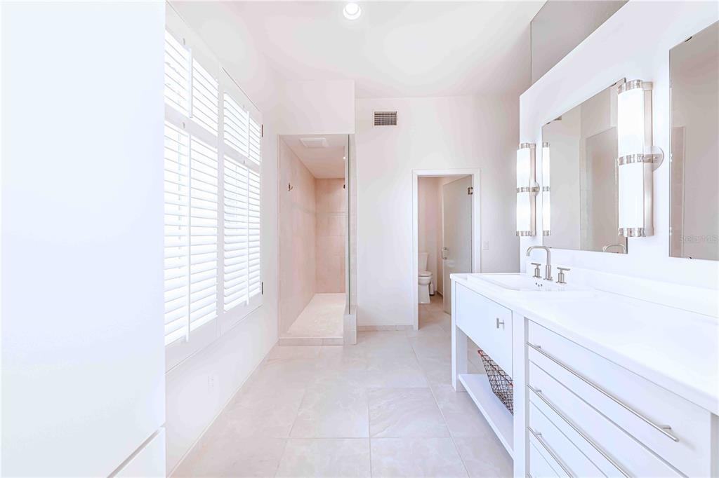 16250 Sunset Pines Circle Boca Grande, FL 33921 - Photo 21 of 48 a spacious bathroom with a double vanity sink a mirror and a bathtub