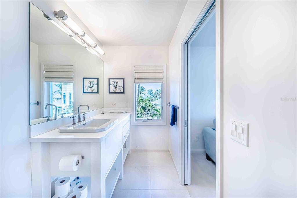 16250 Sunset Pines Circle Boca Grande, FL 33921 - Photo 27 of 48 a en suite bathroom with a sink a mirror and a shower