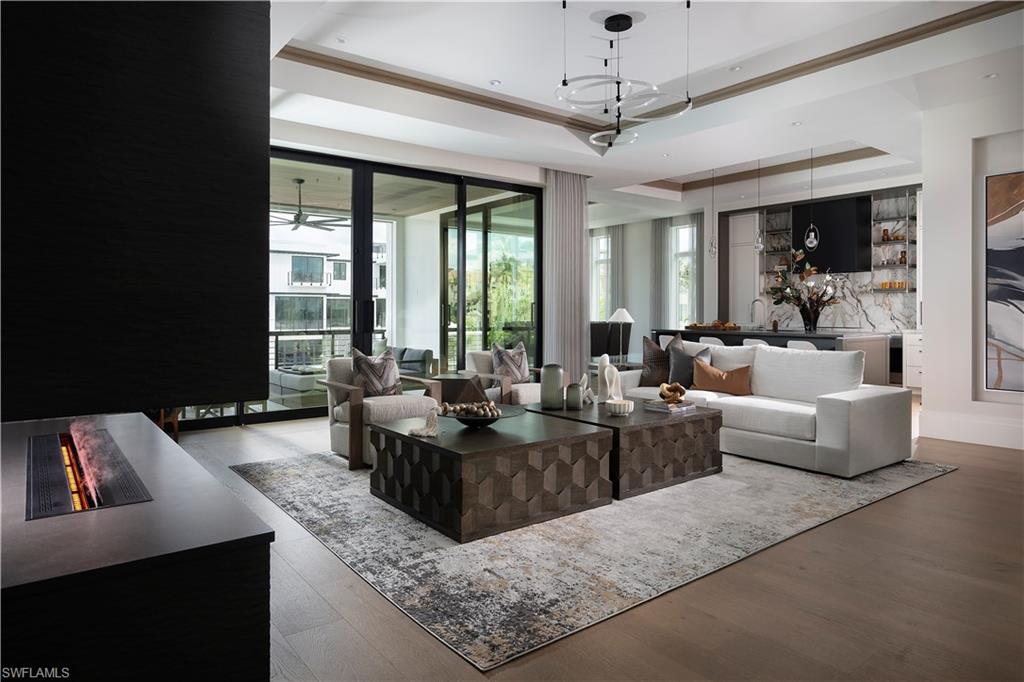 141 Channel Drive Naples, FL 34108 - Photo 4 of 28 Living room featuring a raised ceiling, plenty of natural light, and wood finished floors