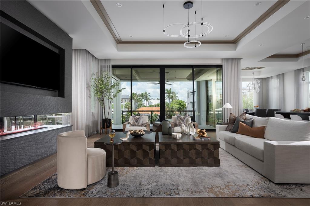141 Channel Drive Naples, FL 34108 - Photo 5 of 28 Living room with a tray ceiling and wood finished floors