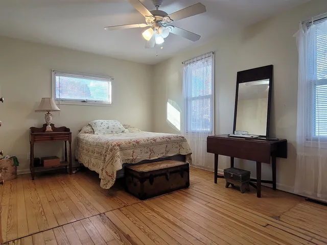 a bedroom with a bed a table and a dresser