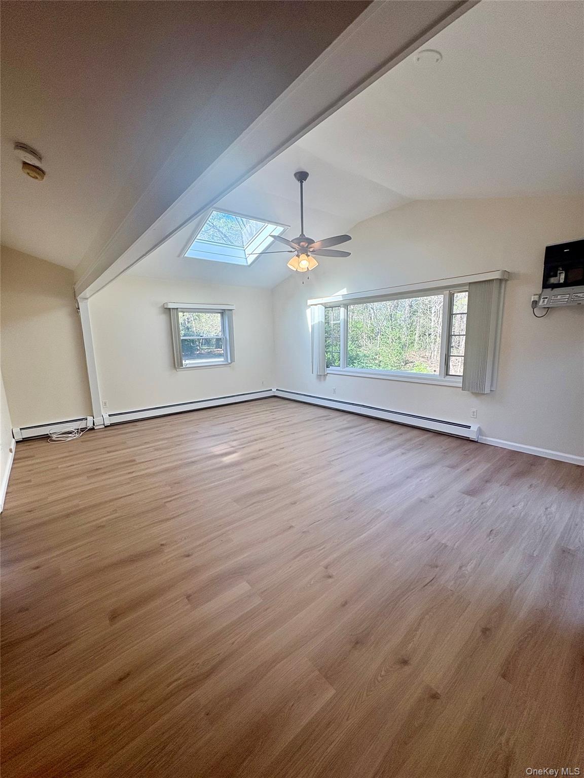 54 Old Brook Road Dix Hills, NY 11746 - Photo 4 of 15 an empty room with wooden floor and windows