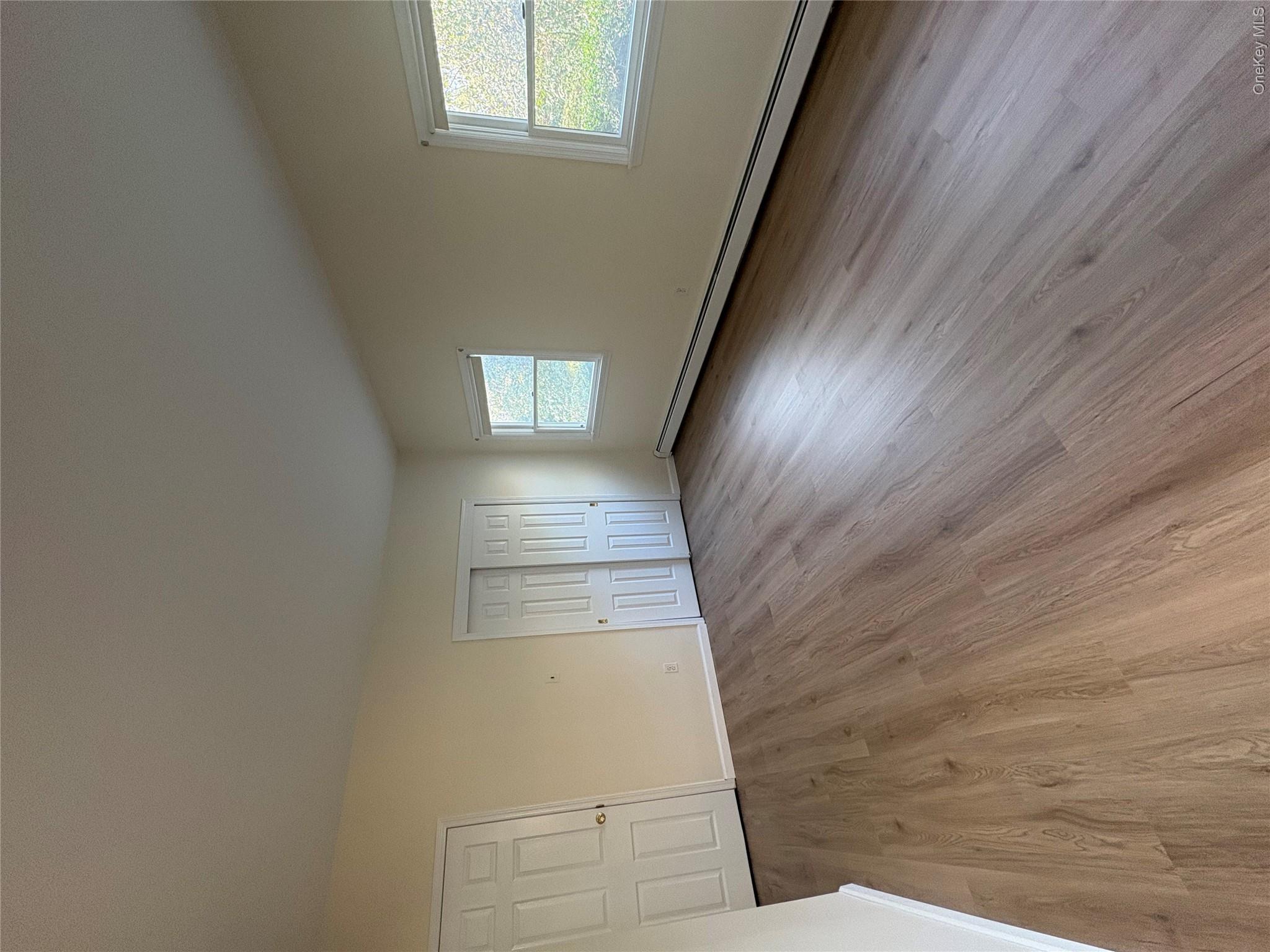 54 Old Brook Road Dix Hills, NY 11746 - Photo 5 of 15 an empty room with wooden floor and windows