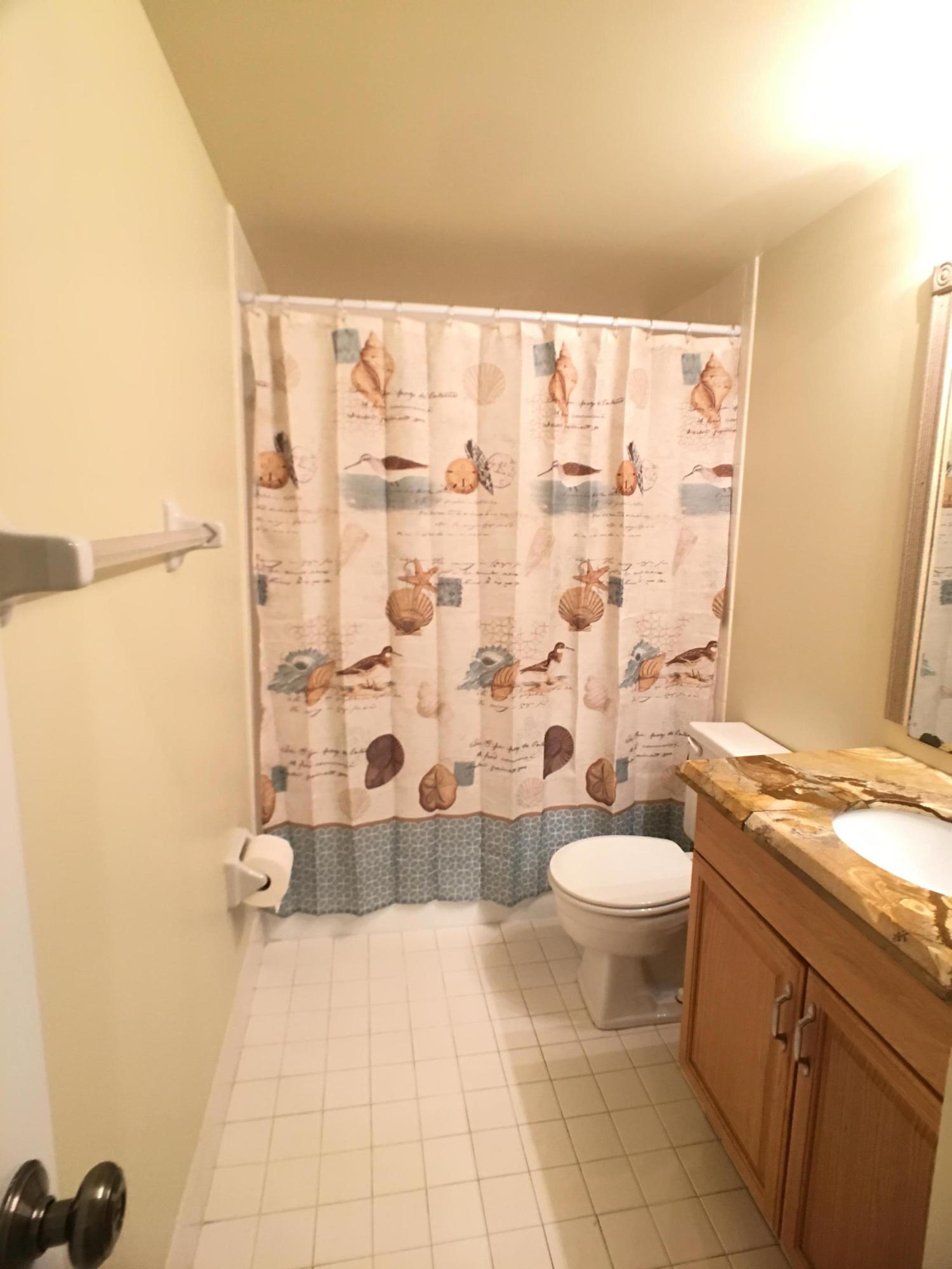 23398 Southwest 57th Avenue, Unit 309 Boca Raton, FL 33428 - Photo 17 of 29 a bathroom with a double vanity sink toilet and shower