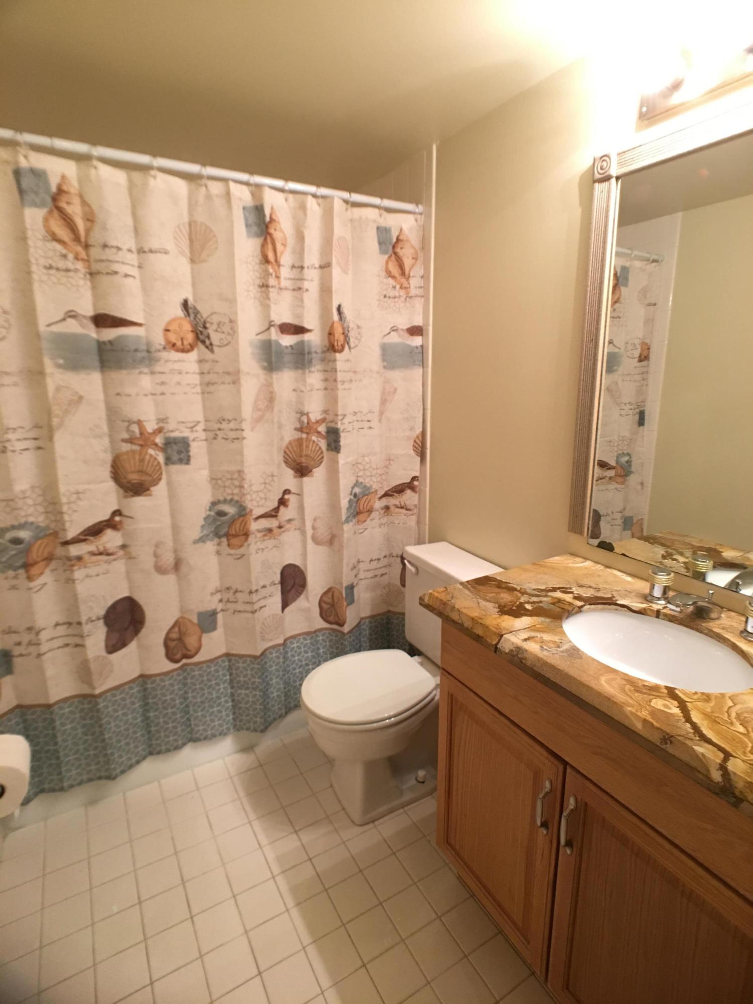 23398 Southwest 57th Avenue, Unit 309 Boca Raton, FL 33428 - Photo 18 of 29 a bathroom with a granite countertop sink toilet and shower