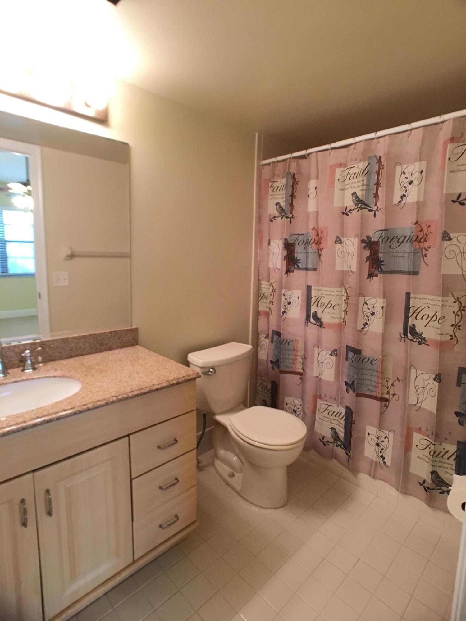 23398 Southwest 57th Avenue, Unit 309 Boca Raton, FL 33428 - Photo 19 of 29 a bathroom with a granite countertop sink a toilet and a mirror
