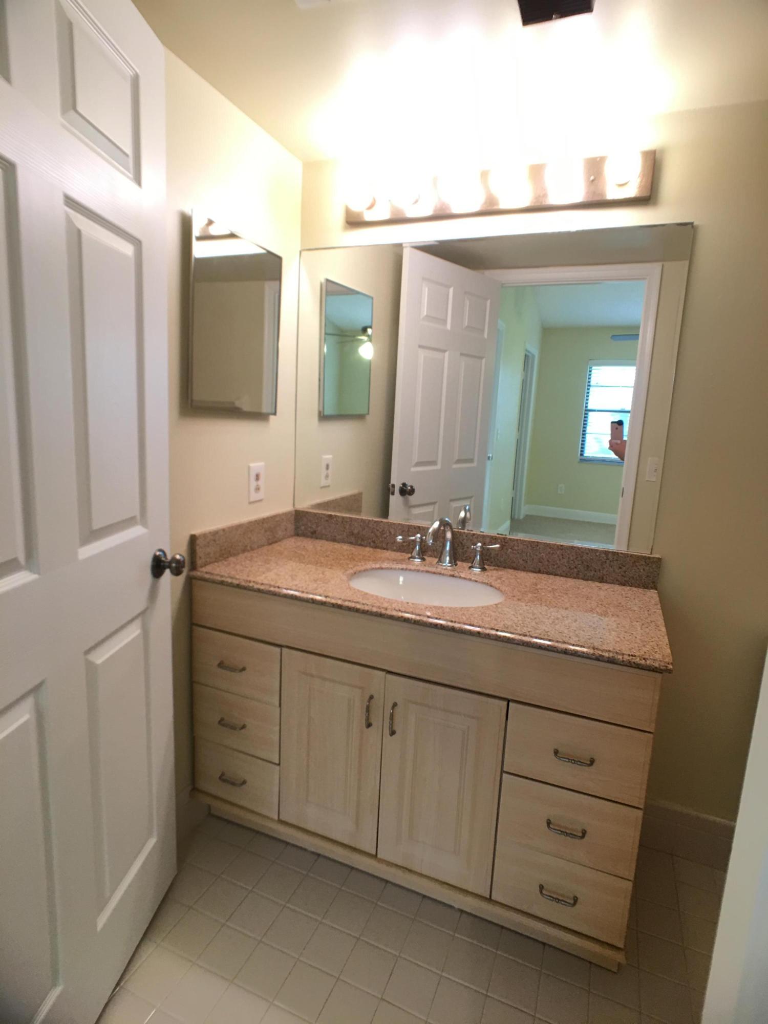 23398 Southwest 57th Avenue, Unit 309 Boca Raton, FL 33428 - Photo 20 of 29 a bathroom with a granite countertop sink mirror and