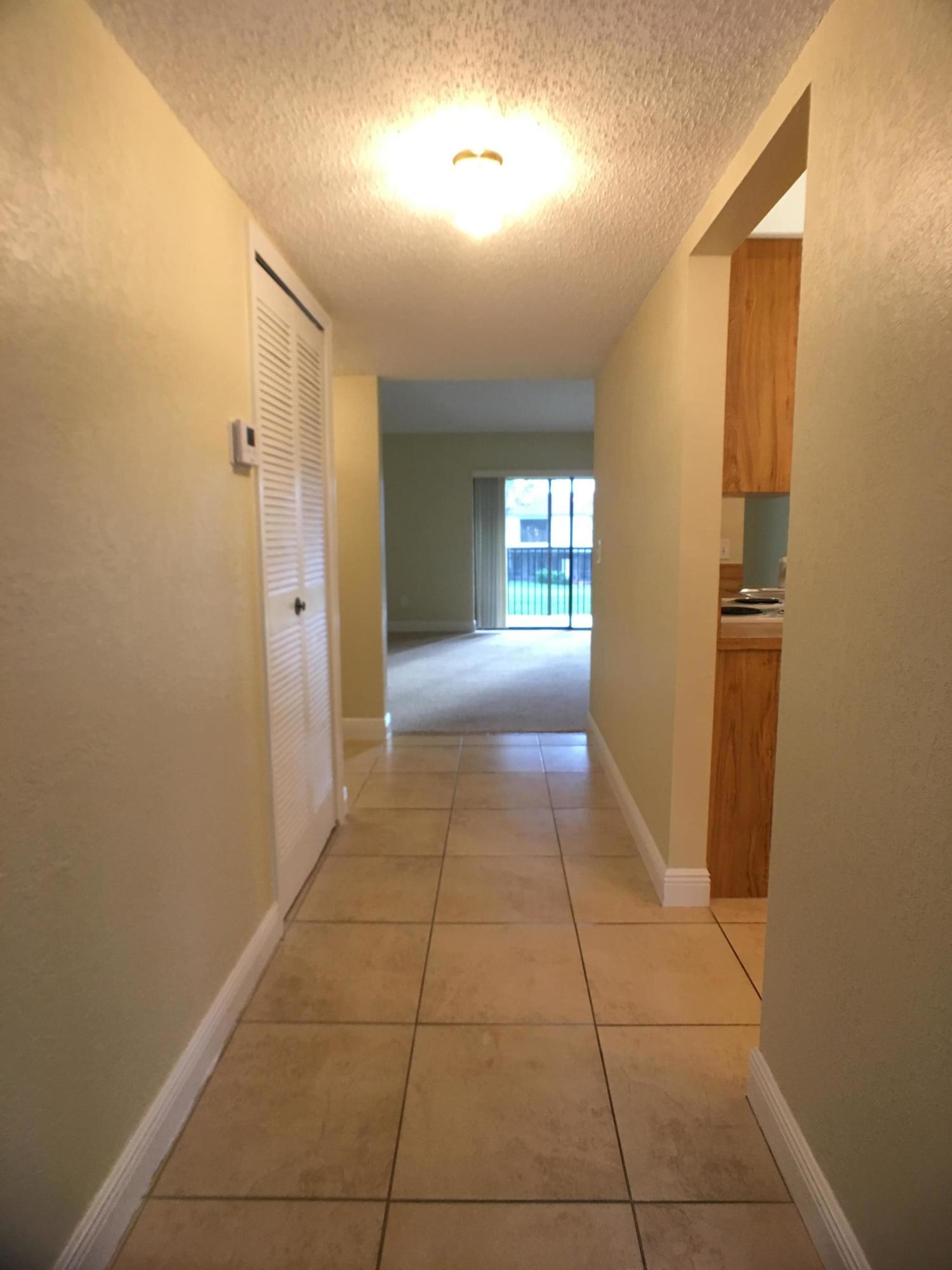 23398 Southwest 57th Avenue, Unit 309 Boca Raton, FL 33428 - Photo 2 of 29 a view of hallway with a window and a livingroom
