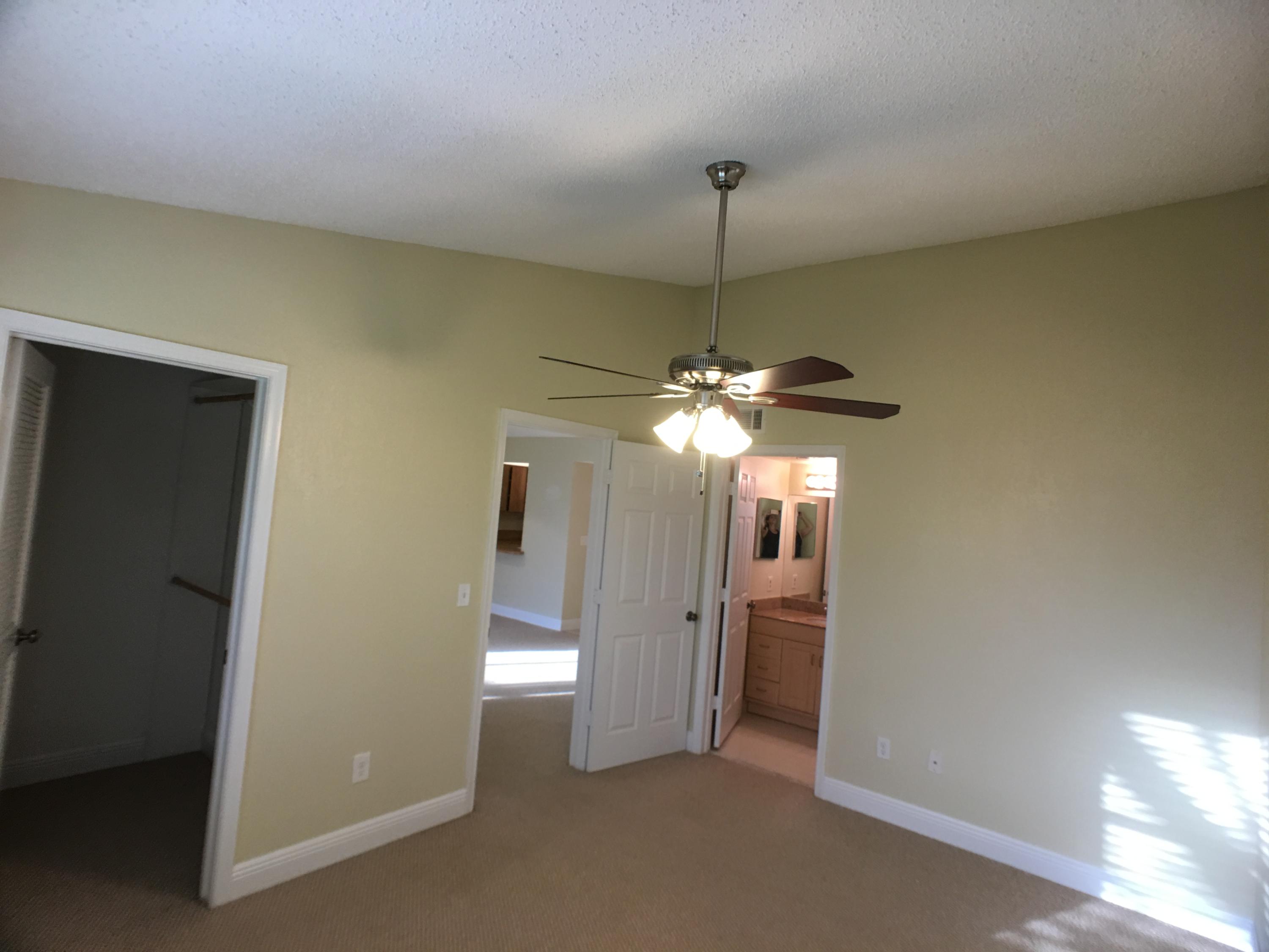 23398 Southwest 57th Avenue, Unit 309 Boca Raton, FL 33428 - Photo 22 of 29 a view of a room with a chandelier fan and windows