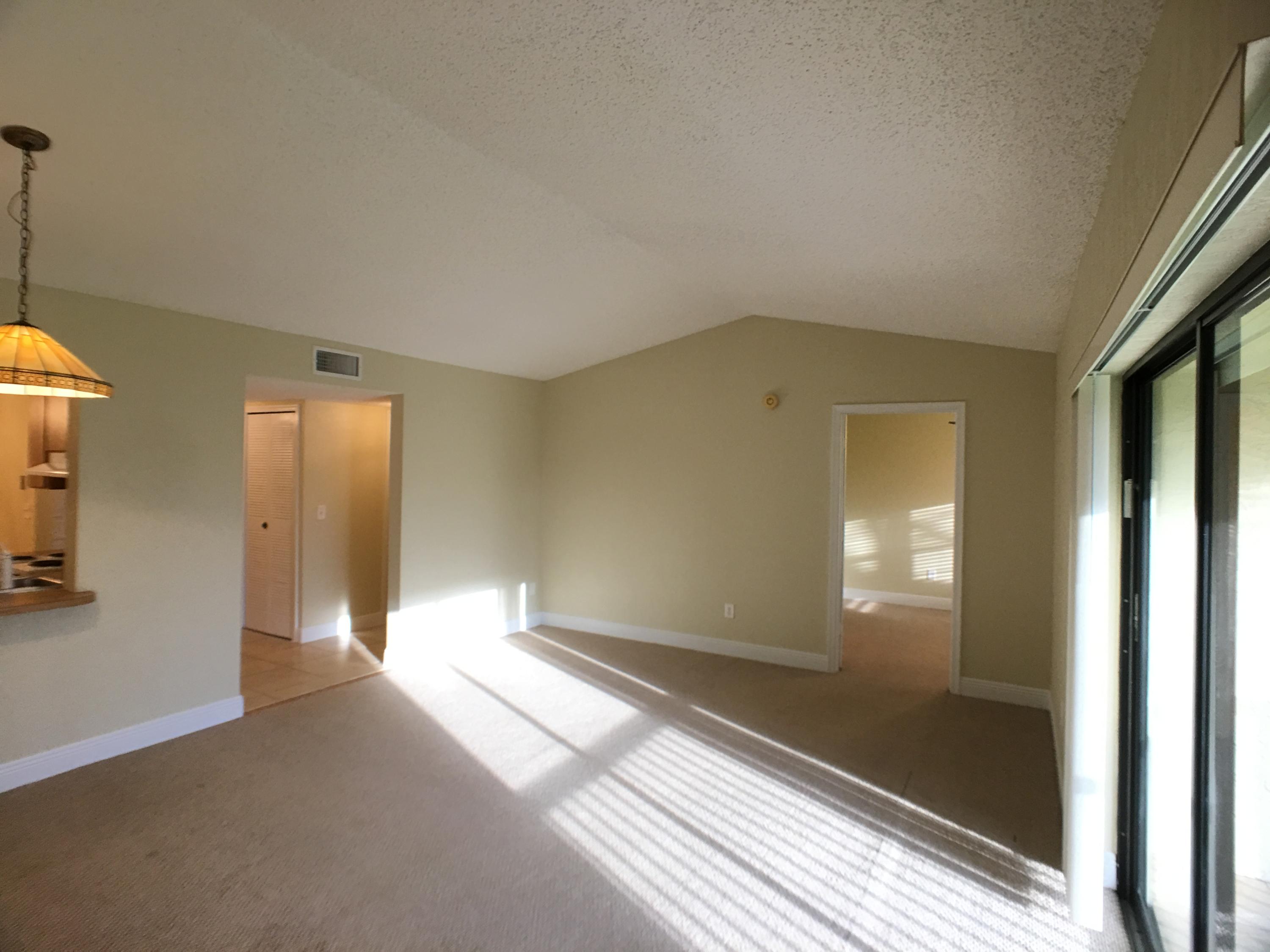 23398 Southwest 57th Avenue, Unit 309 Boca Raton, FL 33428 - Photo 6 of 29 a view of a room with wooden floor and windows