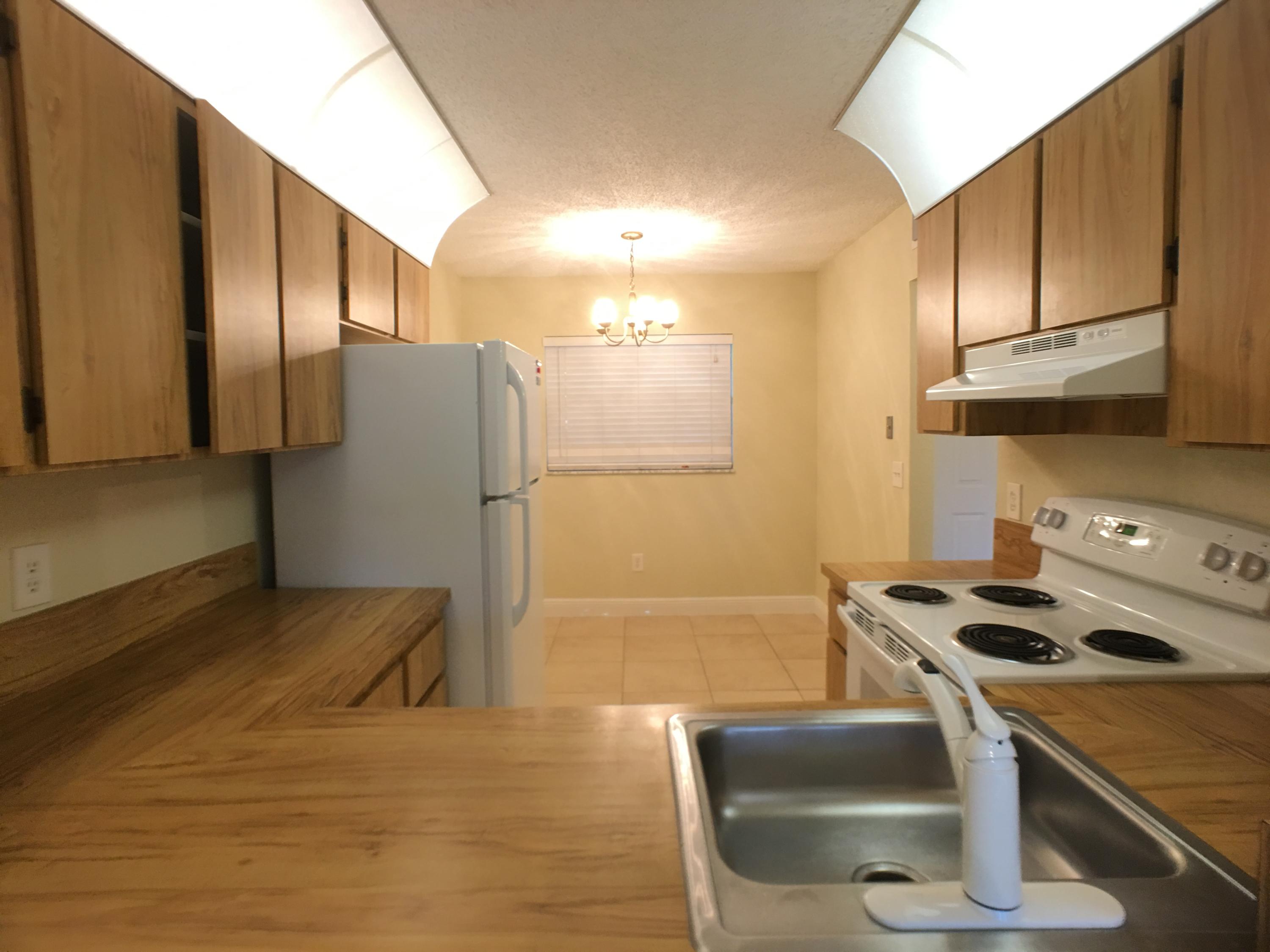 23398 Southwest 57th Avenue, Unit 309 Boca Raton, FL 33428 - Photo 10 of 29 a kitchen with stainless steel appliances granite countertop a sink stove and refrigerator
