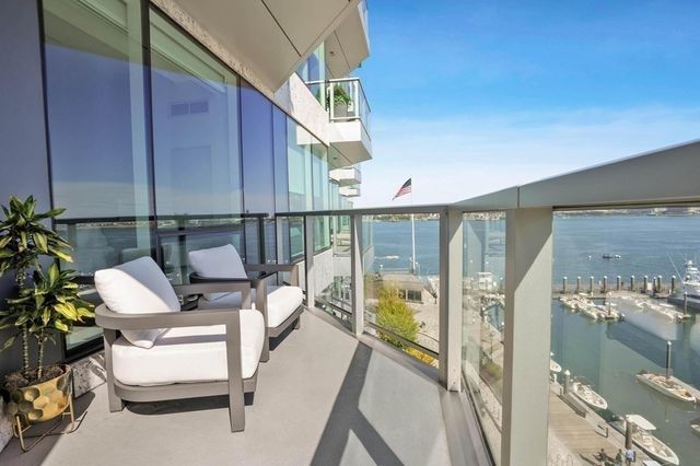 a balcony with wooden floor and outdoor seating