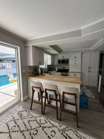 a kitchen with stainless steel appliances granite countertop a refrigerator a stove a sink and a microwave