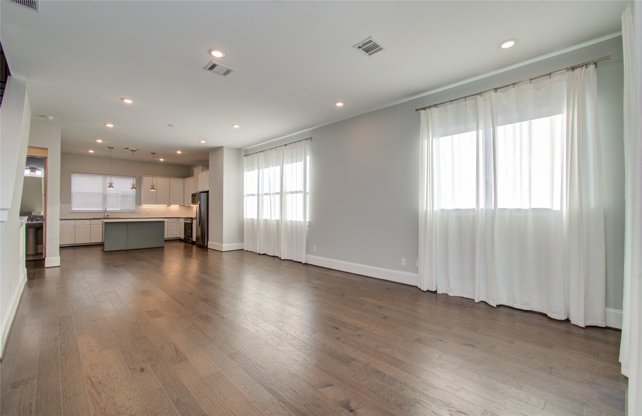 1262 North Post Oak Road, Unit A Houston, TX 77055 - Photo 27 of 50 Looking back across the entire floor, this perspective connects the spacious open lounge to the kitchen in the far background, highlighting the home's cohesive modern finishes.