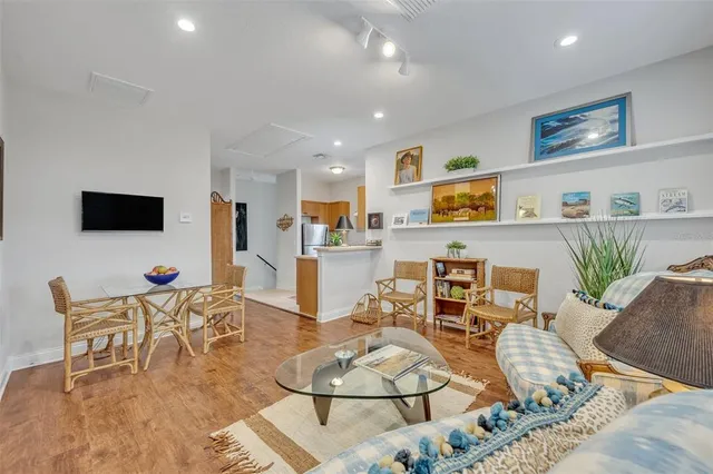 a living room with furniture and a flat screen tv with kitchen view