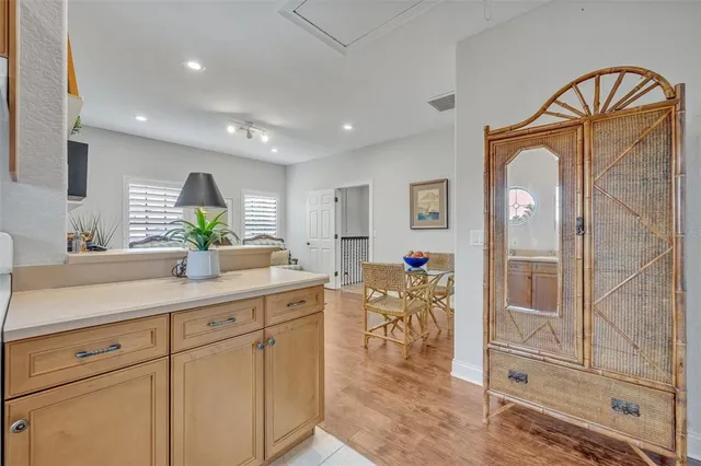 a spacious en suite bathroom with a granite countertop sink a mirror a vanity and a bathtub