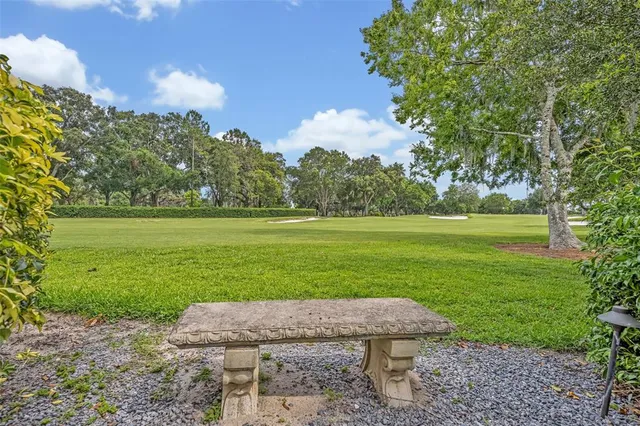 a wooden bench sitting in the grass near a lake
