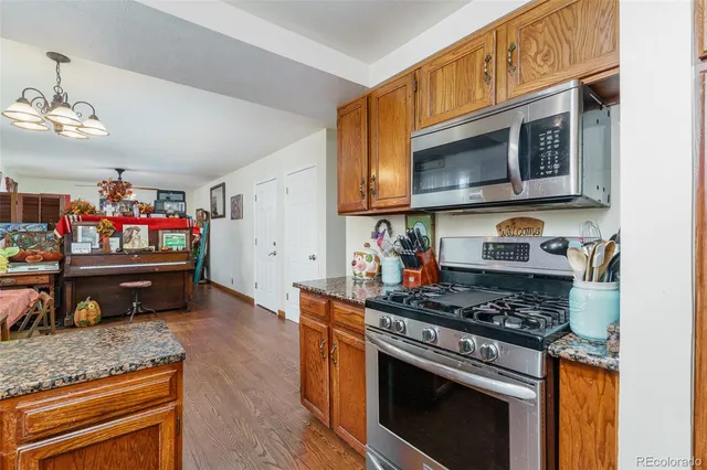 a kitchen with stainless steel appliances granite countertop a stove a microwave and cabinets
