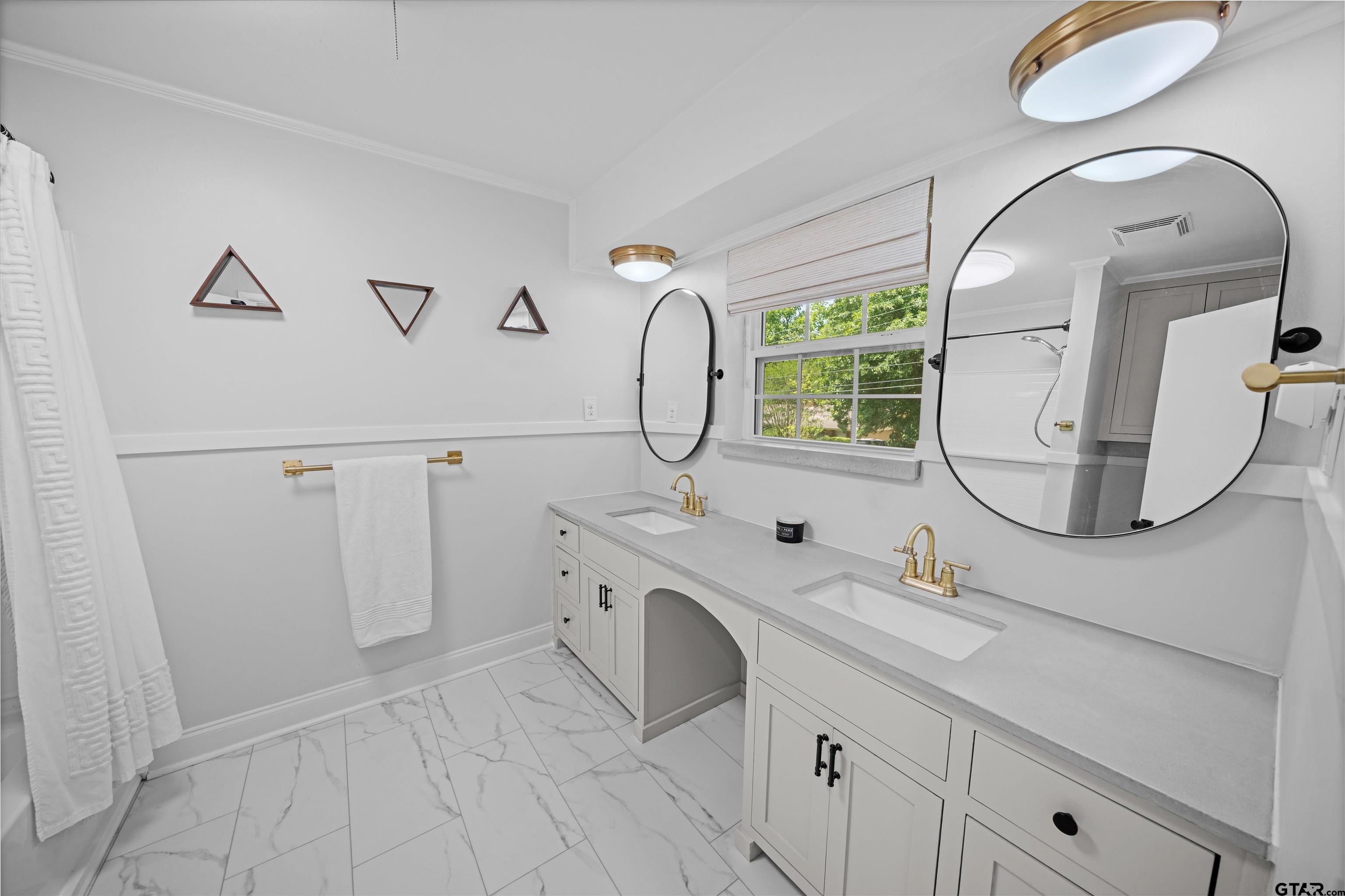 917 Rhodes Drive Tyler, TX 75701 - Photo 19 of 27 a bathroom with a double vanity sink and mirror with window