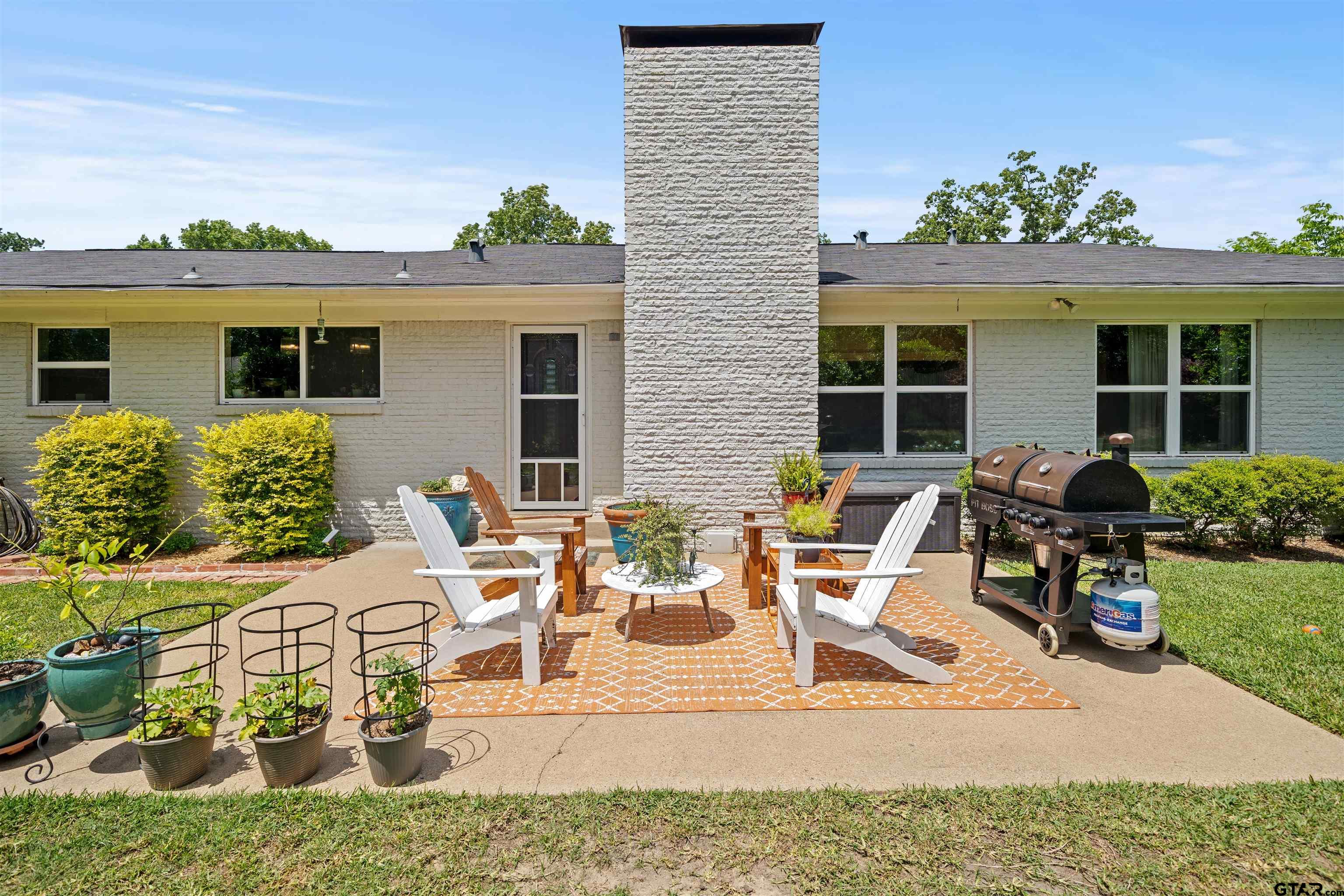917 Rhodes Drive Tyler, TX 75701 - Photo 23 of 27 a view of a house with patio furniture and potted plants