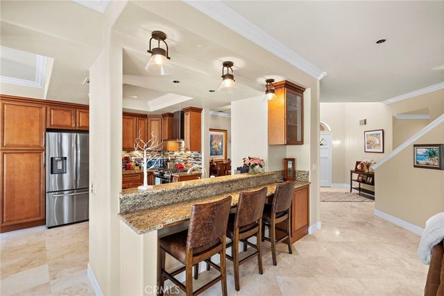 a kitchen with stainless steel appliances kitchen island granite countertop a refrigerator and microwave