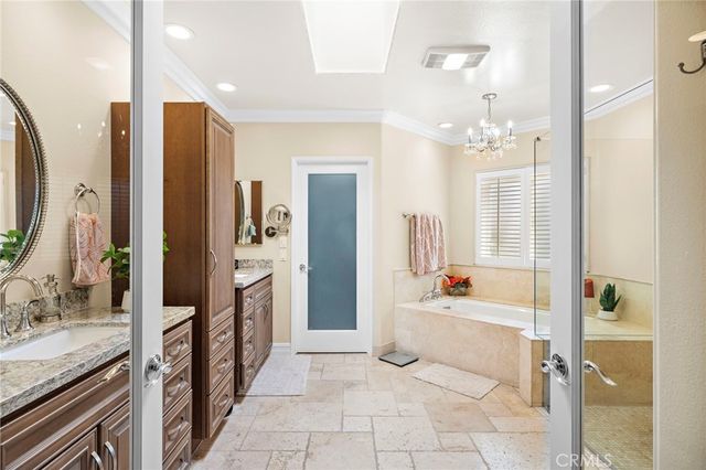 a spacious bathroom with a tub sink and mirror