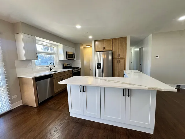 a kitchen with a sink a window and wooden cabinets