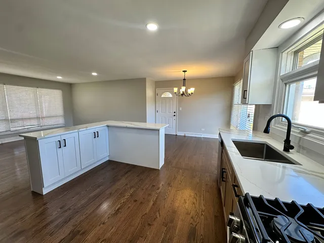 a large kitchen with lots of counter space and wooden floor