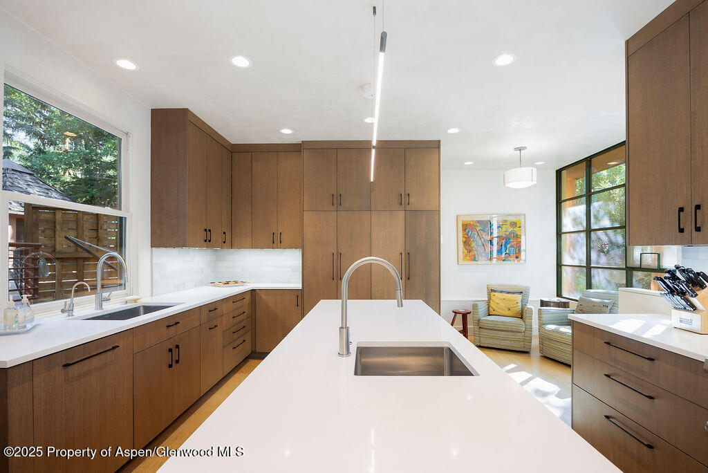 a large kitchen with kitchen island a large counter top space a sink stainless steel appliances and cabinets