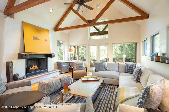 a living room with furniture a fireplace and a large window