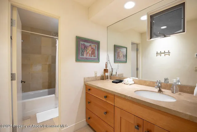 a bathroom with a granite countertop sink mirror and a bath tub