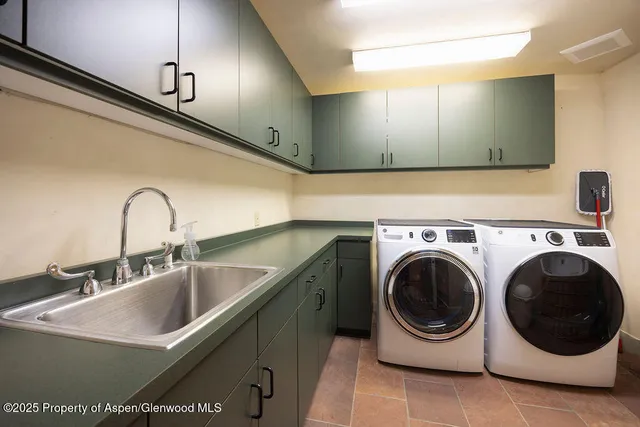 a utility room with sink dryer and washer