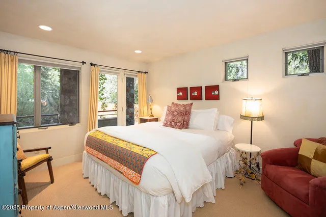 a bedroom with a bed and a large window