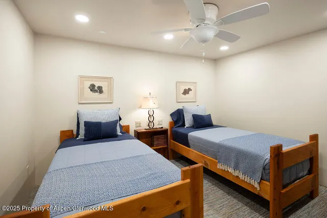 a bedroom with two beds and a chandelier