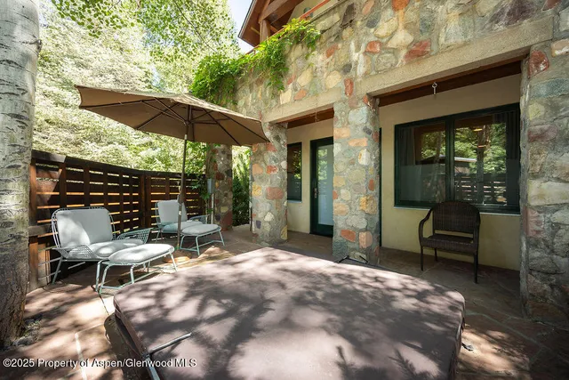 a view of patio with table and chairs under an umbrella