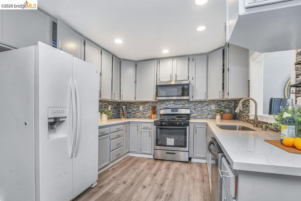 2191 East Cypress Road Oakley, CA 94561 - Photo 8 of 48 Kitchen featuring gray cabinets, stainless steel appliances, light wood finished floors, light stone countertops, and recessed lighting