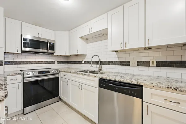 a kitchen with stainless steel appliances granite countertop a stove and a microwave