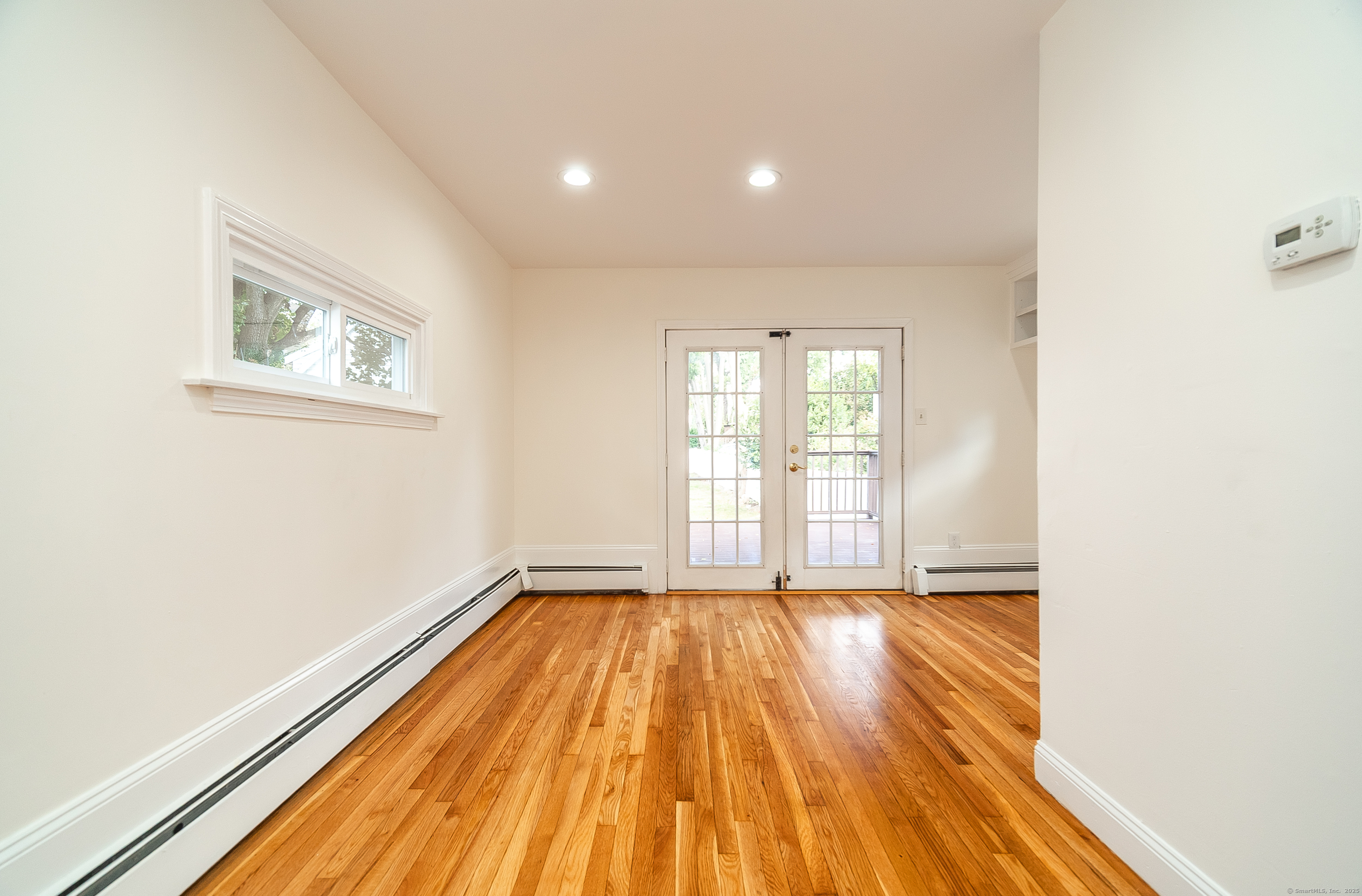 78 Warren Street Stamford, CT 06902 - Photo 8 of 40 a view of an empty room with wooden floor and a window