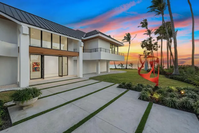 a front view of a house with a yard and potted plants