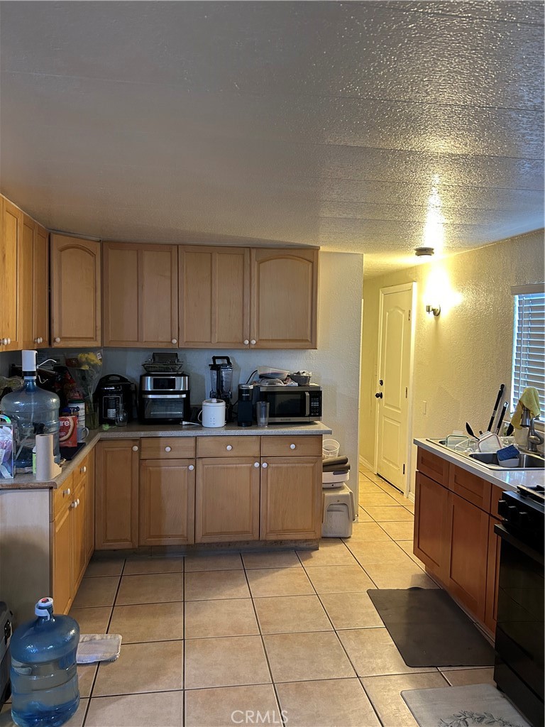 21900 Martin Street, Unit A8 Carson, CA 90745 - Photo 9 of 10 a kitchen with stainless steel appliances granite countertop a stove a sink and a refrigerator