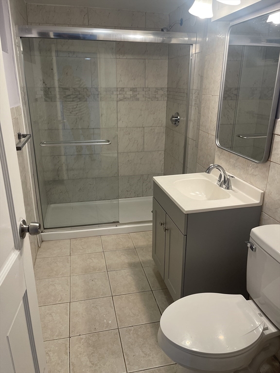 23 Spring Street, Unit B Malden, MA 02148 - Photo 9 of 9 a bathroom with a toilet a sink a mirror and a shower