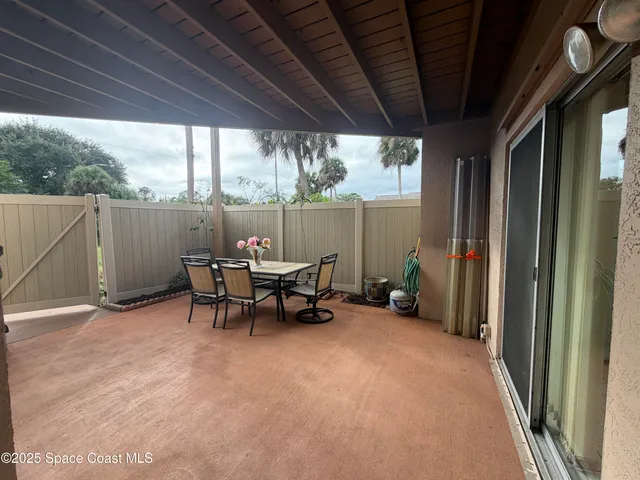 a view of a patio with table and chairs next to a yard