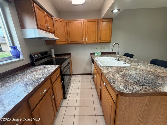 a kitchen with a sink a stove and cabinets