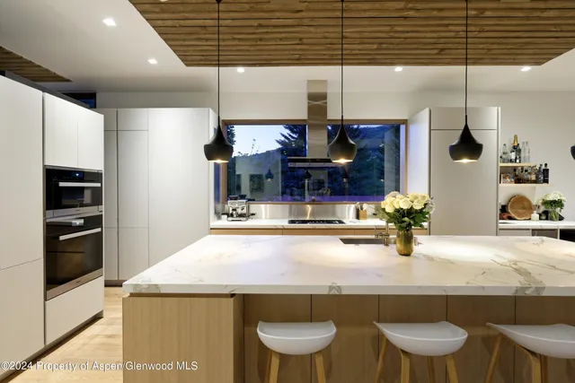 a kitchen with a sink a stove and chairs