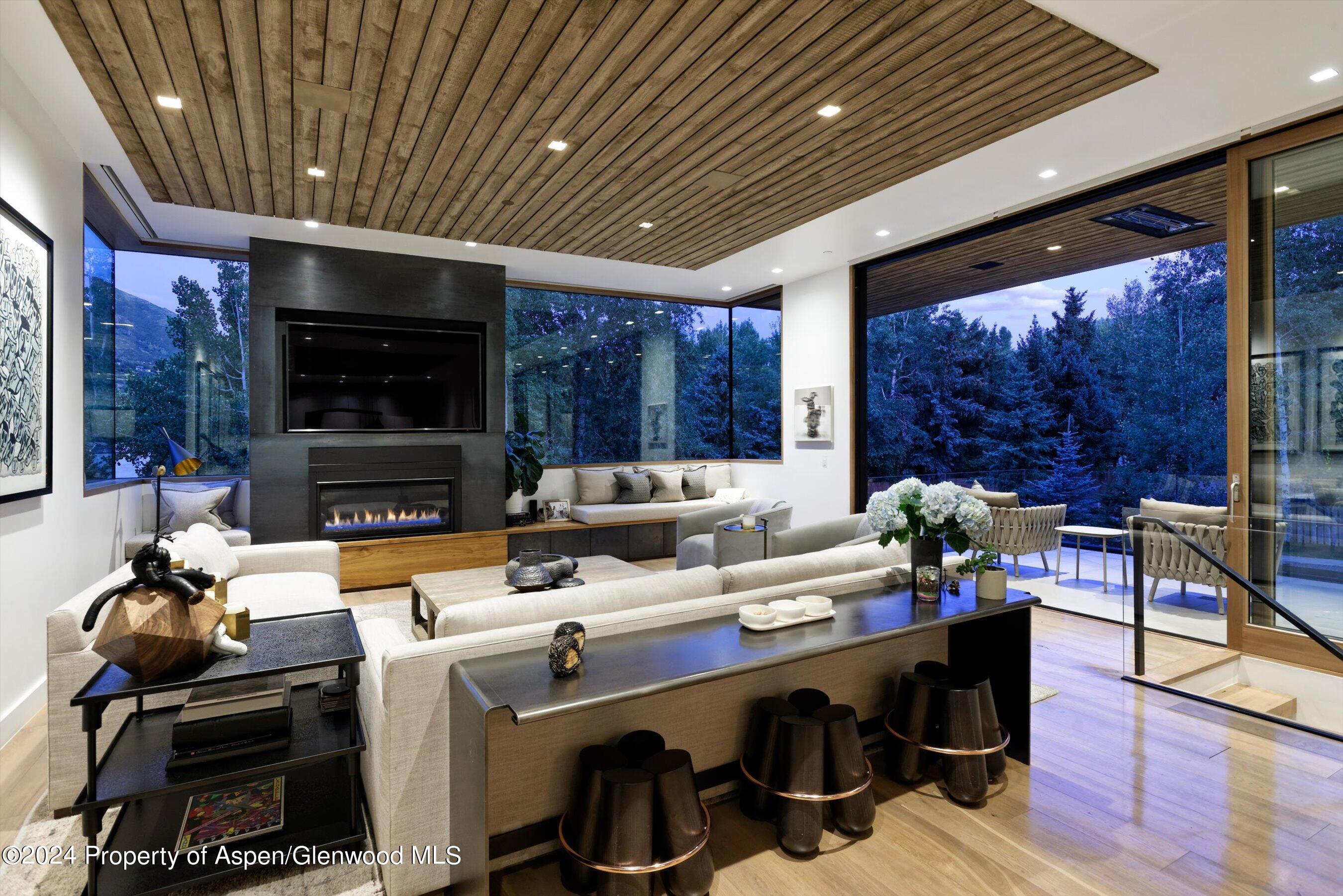 1035 Cemetery Lane Aspen, CO 81611 - Photo 2 of 41 a living room with furniture a flat screen tv and floor to ceiling window