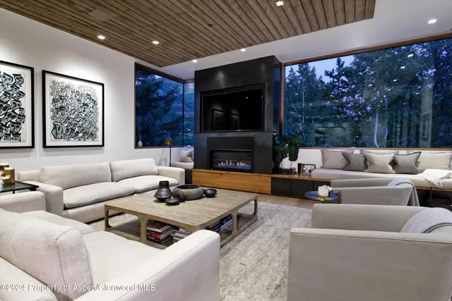 a living room with furniture a large window and a fireplace