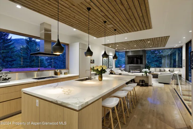 a kitchen with stainless steel appliances granite countertop a sink a stove and a wooden cabinets