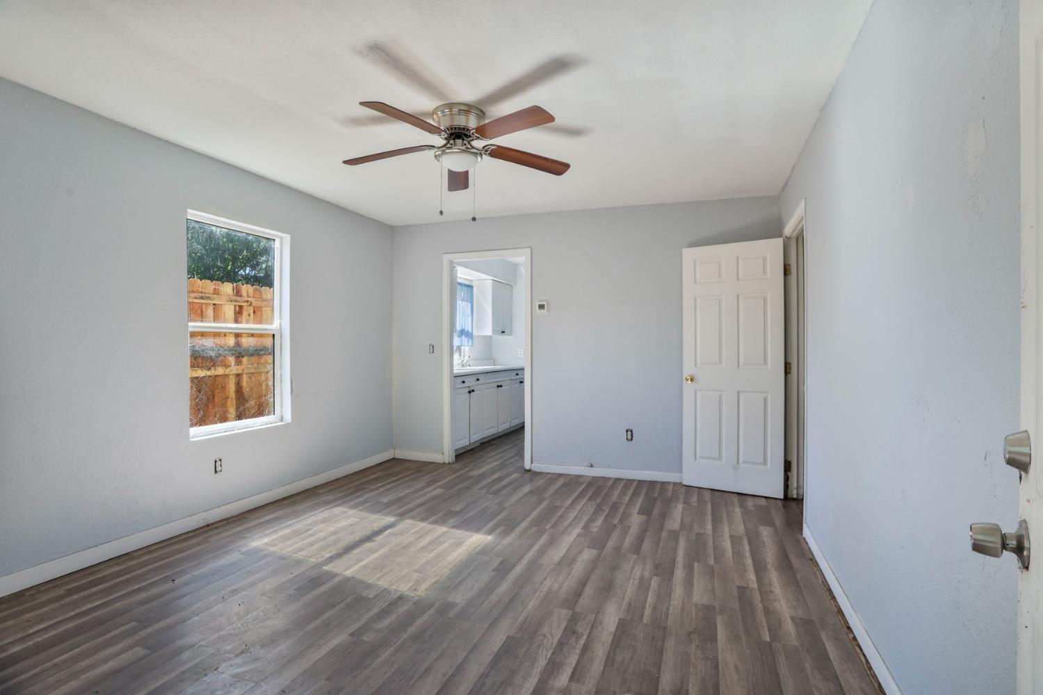 916 Elm Avenue Modesto, CA 95351 - Photo 36 of 52 Rear dwelling living area with ceiling fan, natural light, wood-look flooring, and access toward kitchen.